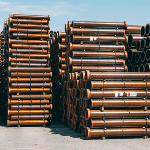 Gestapelte Metallrohre auf Lagerplatz im Freien