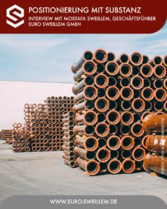 Gestapelte orangefarbene Industrie-Rohre auf Lagerplatz